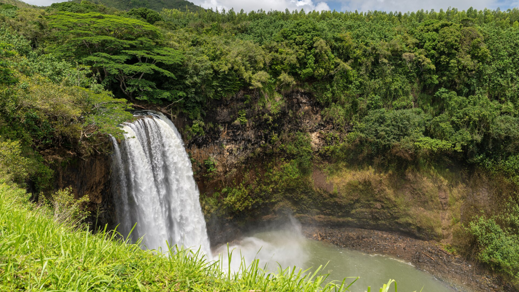 Kauaʻi Travel Guide Wailua Falls surrounded by lush tropical vegetation on Kauaʻi